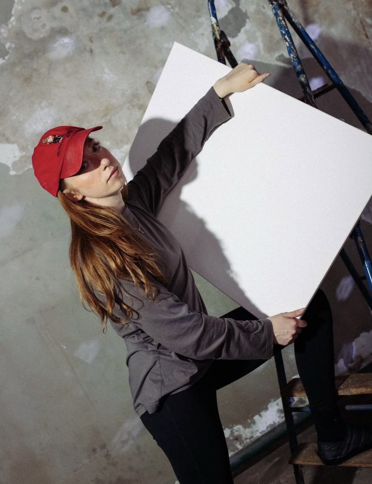 Anastasija Aleksejeva holding a blank canvas