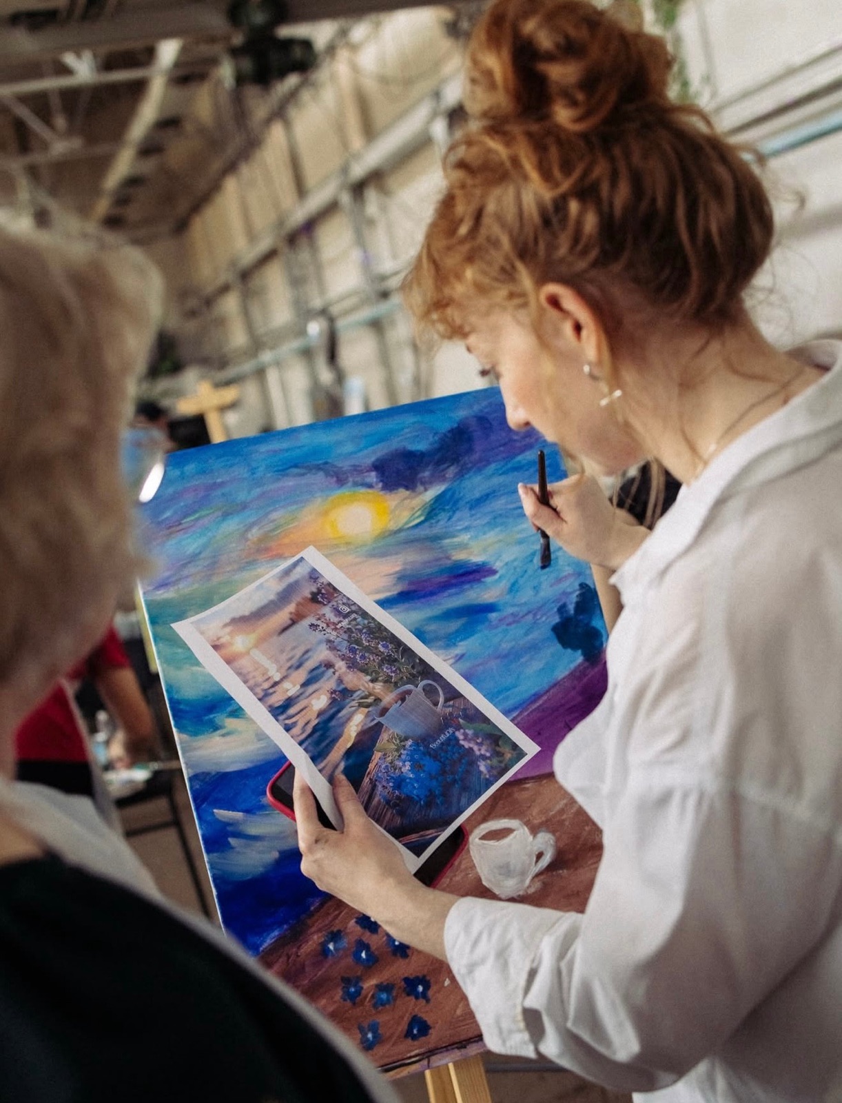 Anastasija Aleksejeva painting a seascape at a workshop